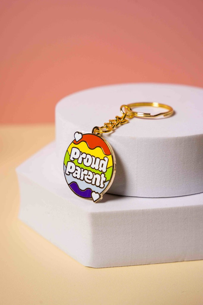 Keychain with rainbow design and 'Proud Parent' text on a white box with pink background