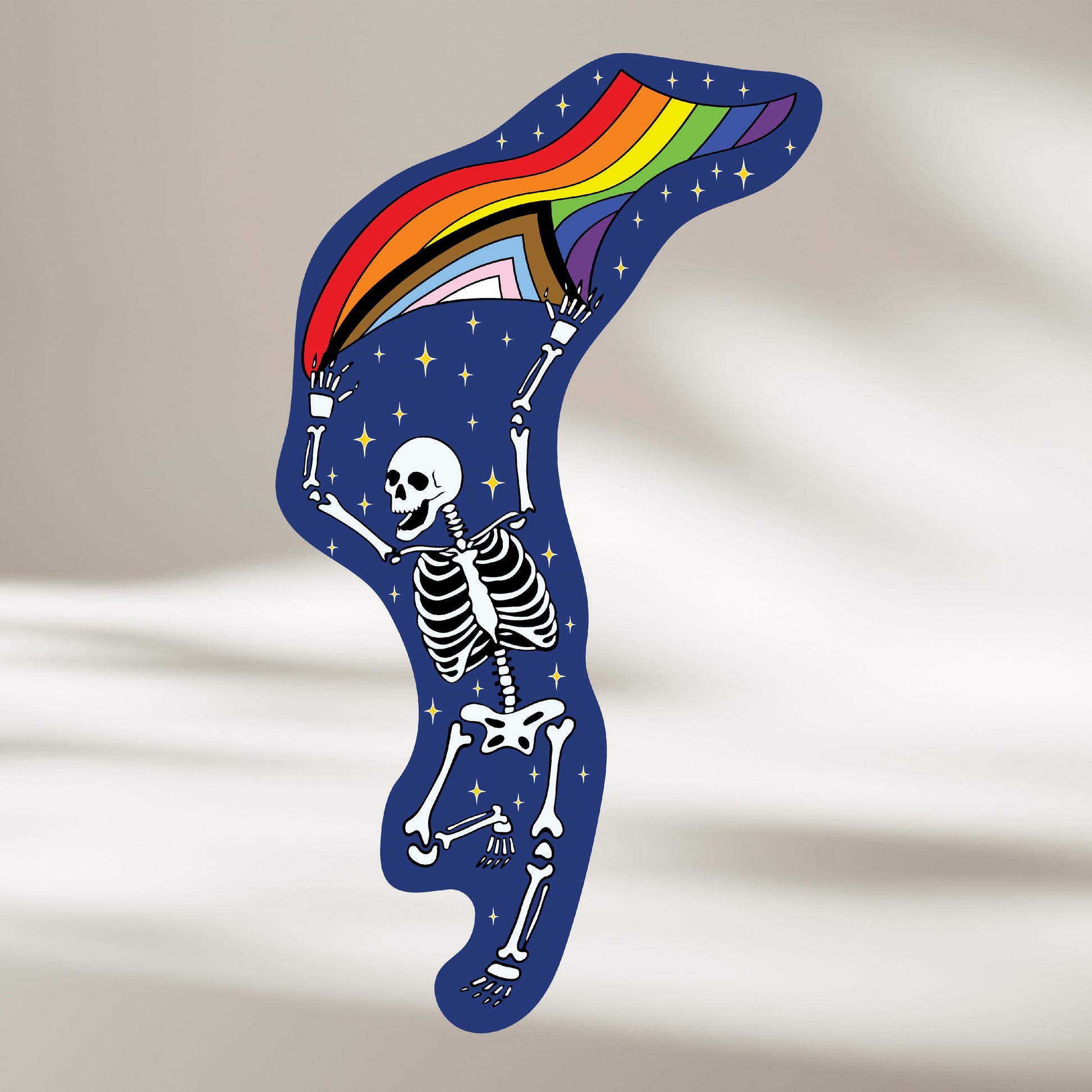 Happy sparkly skeleton graphic with a rainbow flag on a beige background